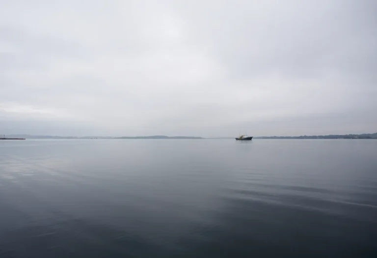 A calm waterway with a fishing boat, symbolizing loss and hope.